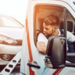uomo sul carroattrezzi carica un auto in panne