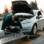 uomo sul carroattrezzi carica un auto in panne
